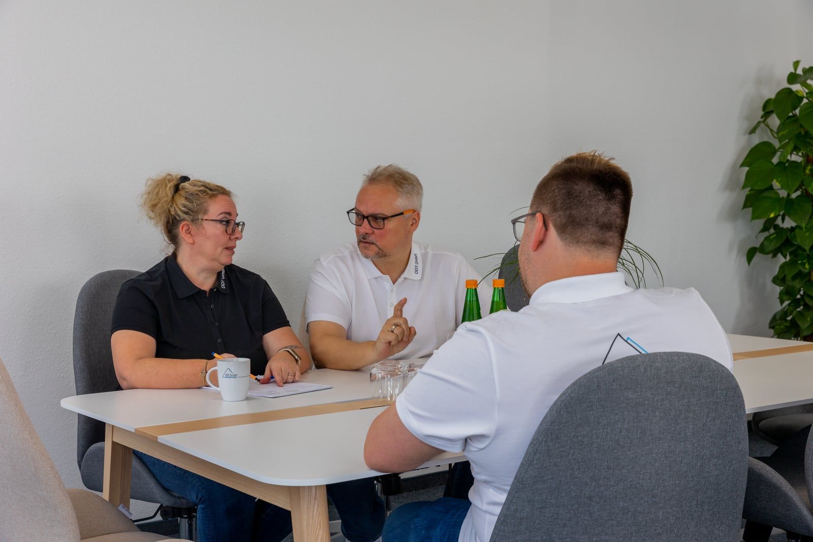 Drei Mitarbeitende der FISEKON GmbH bei einer Projektabstimmung am Besprechungstisch